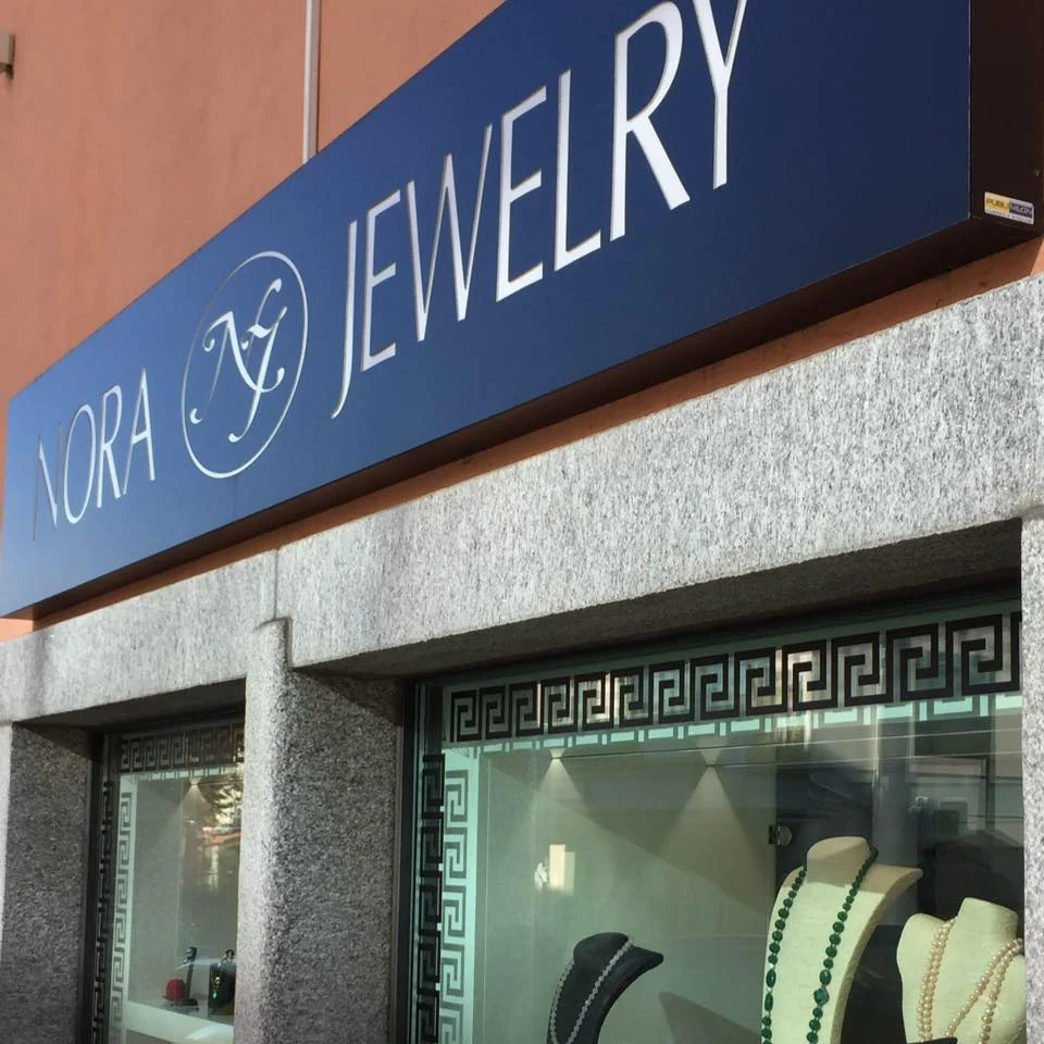 La facciata di Nora Jewelry ad Agno con l'insegna blu e le vetrine con la greca